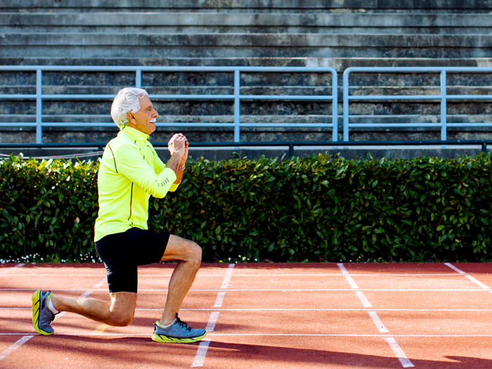 older man doing lunges on track