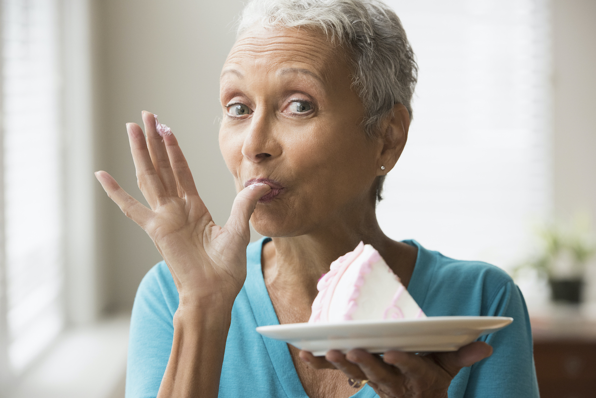 Mujer mayor comiendo torta