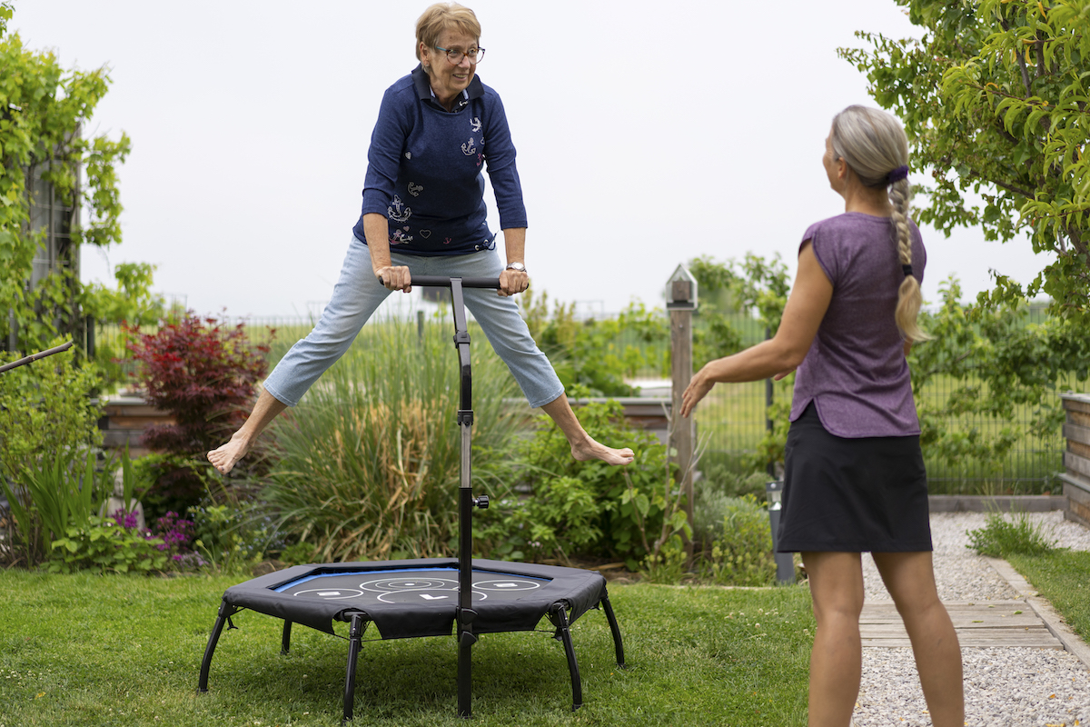 happy senior woman jumping on a mini trampoline
