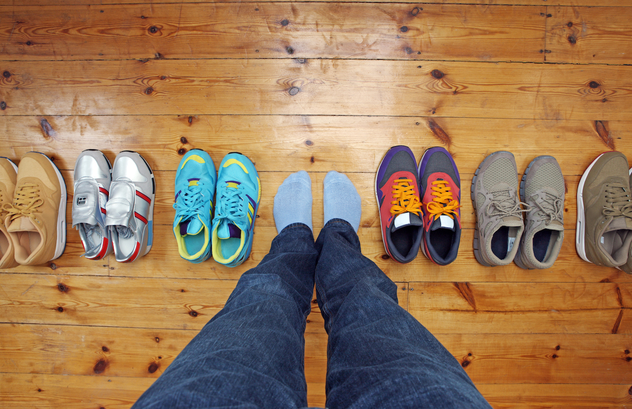 Person standing among several sneakers choices 