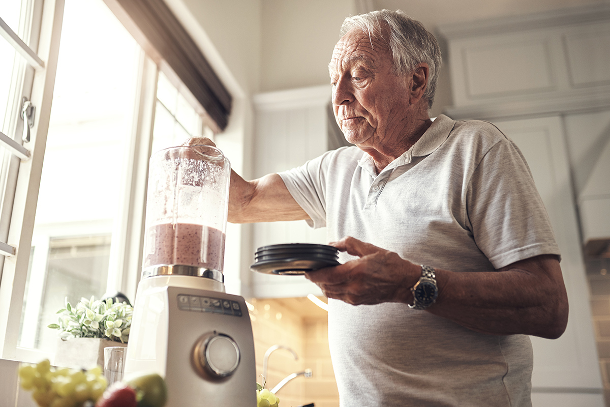 Older man making a smoothie