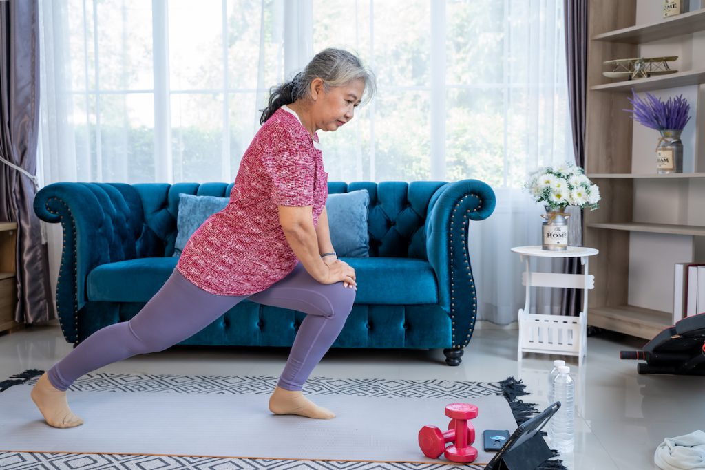 Mature woman exercising and stretching at home