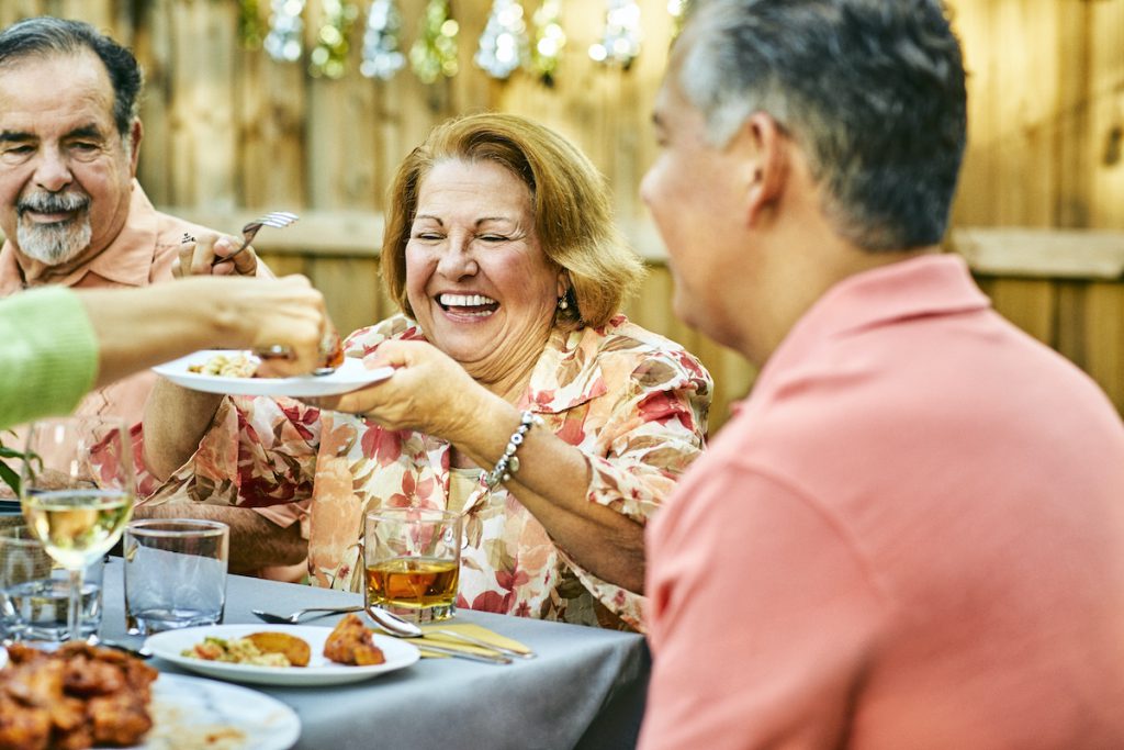 Happy older woman enjoying a family meal outside