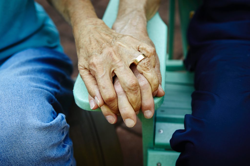 close up shot of seniors holding hands