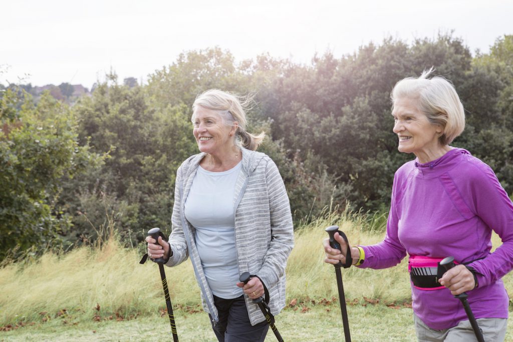 two senior women nordic walking for a story on the secrets of super agers