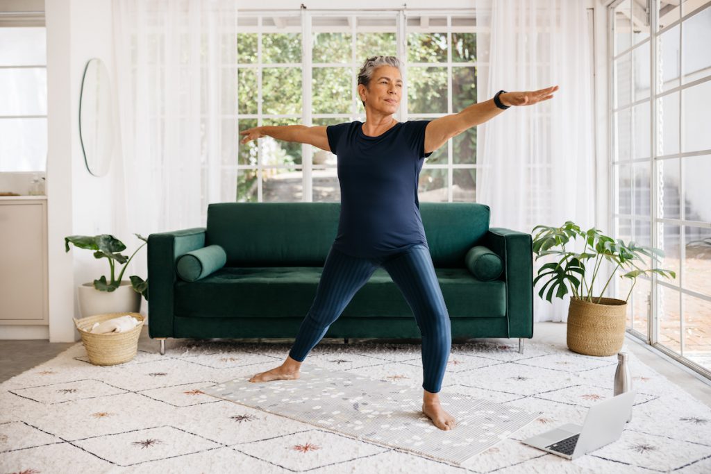 senior woman practicing yoga at home for a story on yoga flows to improve balance
